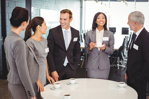 Businesspeople having tea and interacting during breaktime in office