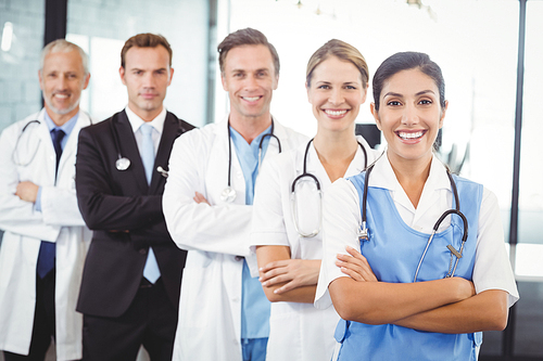 Portrait of happy medical team standing with arms crossed in hospital