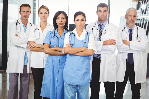 Portrait of medical team standing with arms crossed in hospital