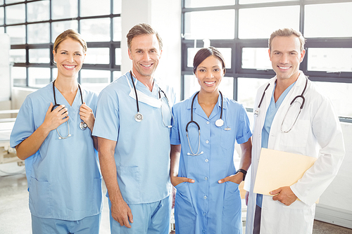 Portrait of happy medical team standing together in hospital