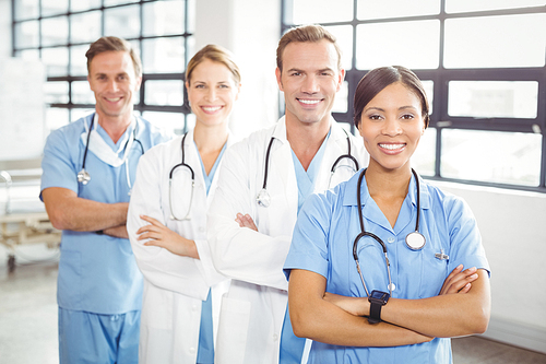 Portrait of happy medical team standing with arms crossed in hospital