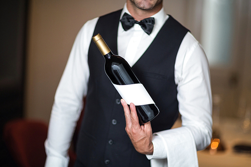 Waiter presenting red wine in a commercial kitchen