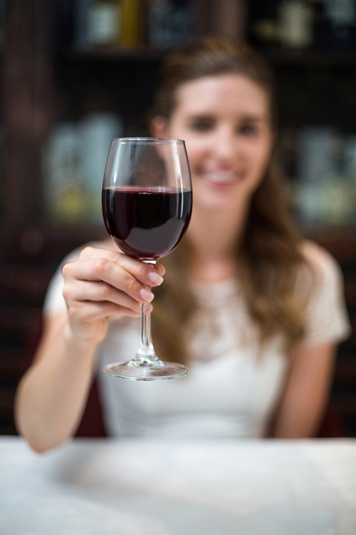 Happy woman holding wine glass at restaurant