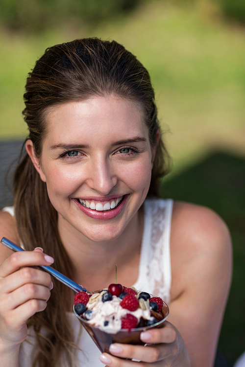 Portrait of smiling happy woman enjoying dessert