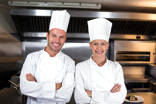 Portrait of happy chefs standing in commercial kitchen