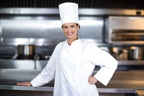 Portrait of happy female chef standing in commercial kitchen