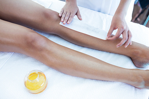 Woman getting her legs waxed at spa