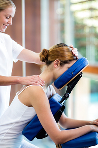 Woman receiving massage in massage chair at spa