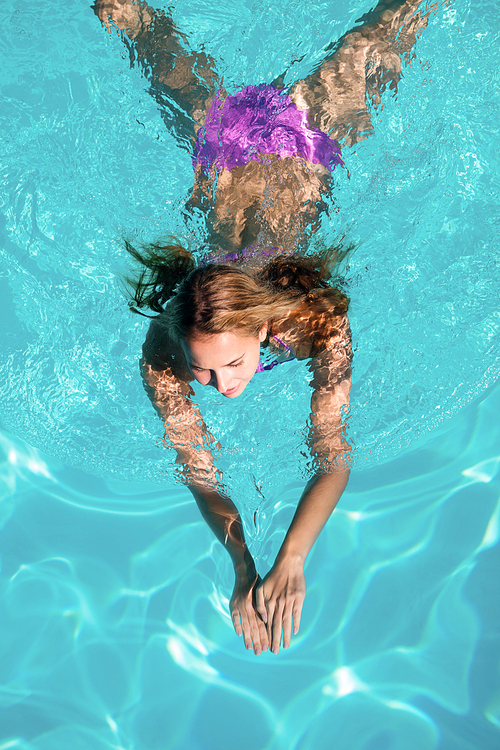 Woman swimming in swimming pool on a sunny day