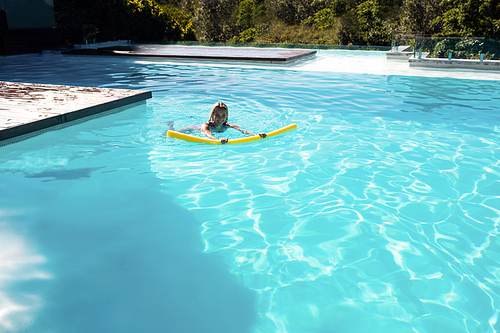 Woman swimming in swimming pool on a sunny day