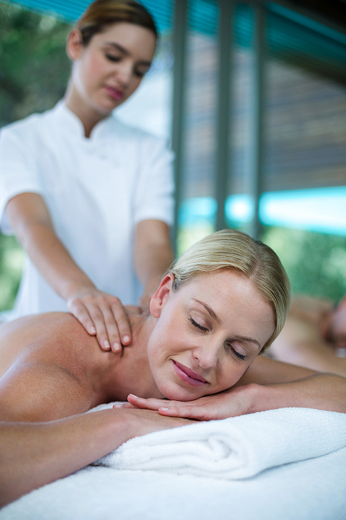 Woman receiving back massage from masseur in spa