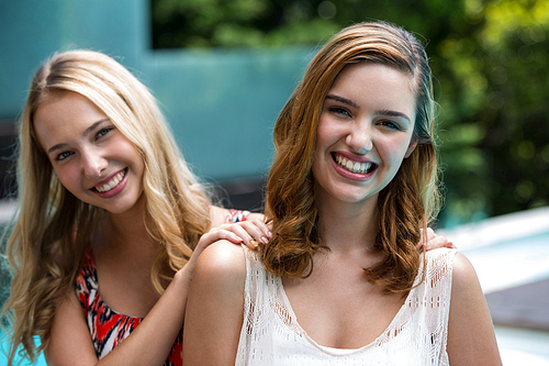 Portrait of beautiful women smiling near pool on a sunny day