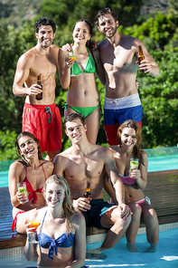 Group of happy friends with beer bottles and glass of cocktail on a sunny day