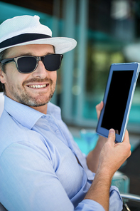 Smart man using a digital tablet near poolside