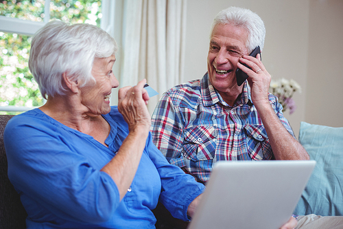 Smiling senior couple using technology at home