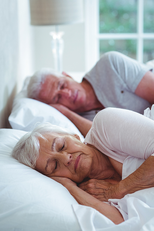 Senior couple relaxing on bed at home