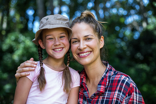 Portrait of cheerful mother with daughter in back yard