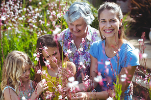 Happy woman with senior woman and girls in back yard during sunny day