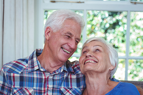 Loving senior couple looking at each other in living room