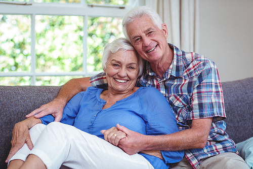 Portrait of smiling senior couple on couch
