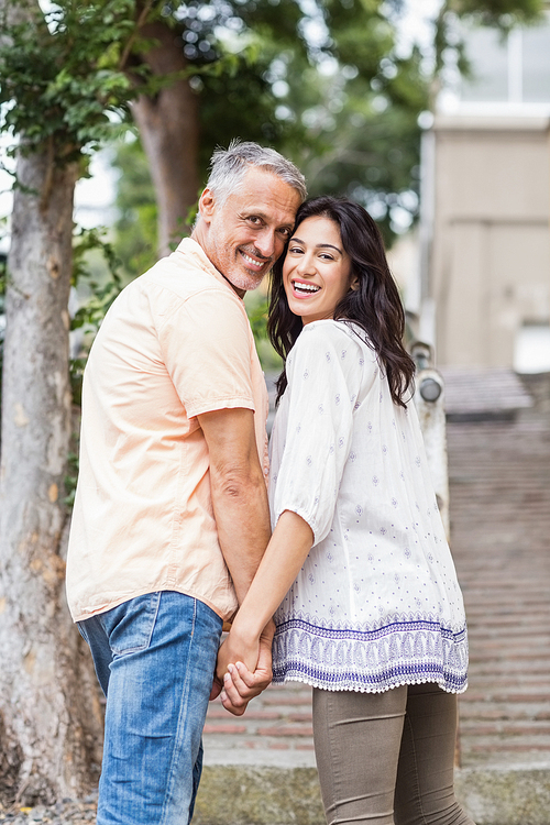 Portrait of happy couple standing in city