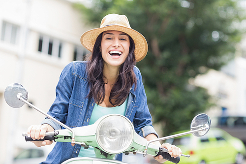 Portrait of woman enjoying moped ride in city