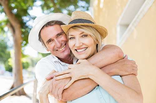 Portrait of cheerful couple embracing in city