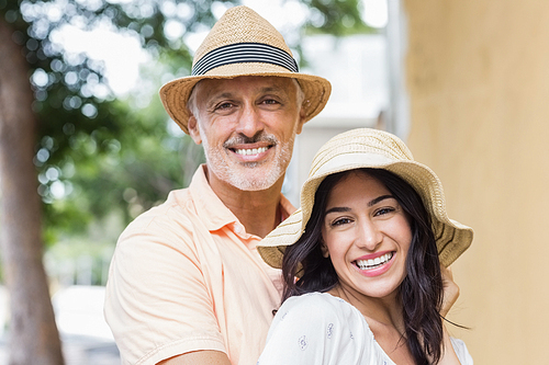 Portrait of smiling couple wearing hats in city