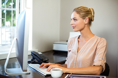 Focused businesswoman working on computer in office