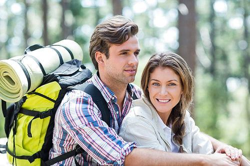 Young couple embracing and sitting in forest