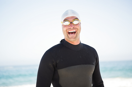 Portrait of smiling fit swimmer on the beach
