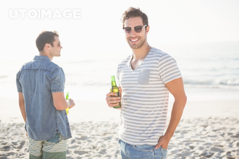 유토이미지 | Friends drinking beer on the beach on a sunny day