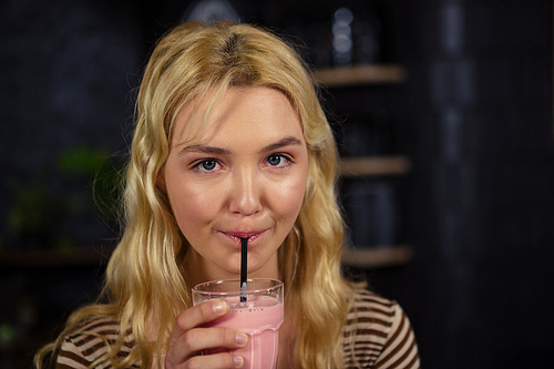 Woman drinking a milkshake in a coffee shop