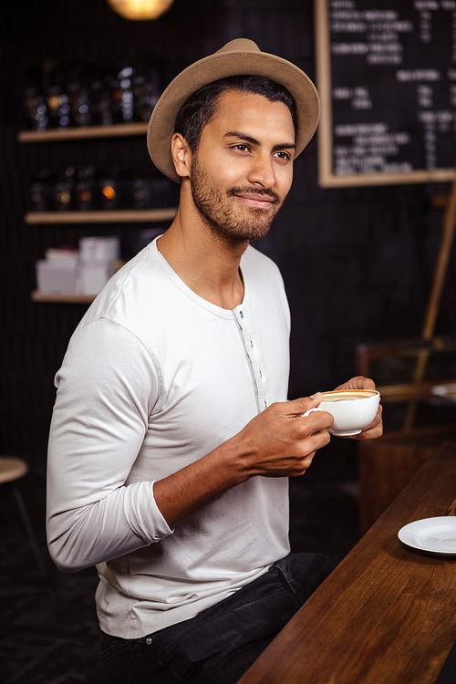 Man holding a cup of coffee in a coffee shop