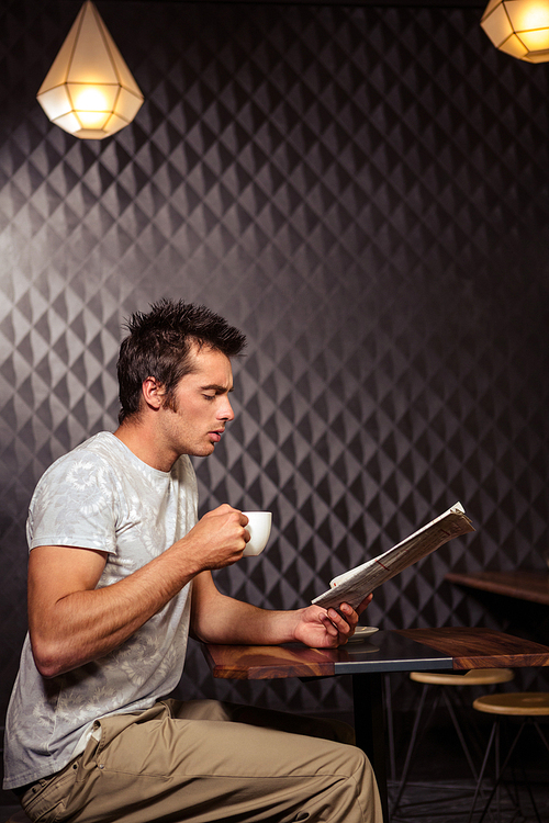 Hipster man reading newspaper in a coffee shop