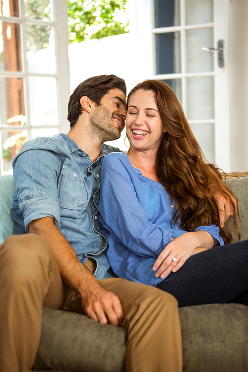 Happy young couple embracing each other in living room