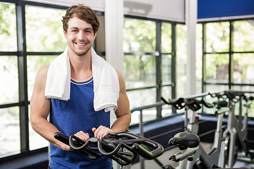 Portrait of happy man standing in spinning class