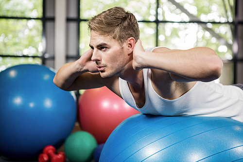 Man working out on a fitness ball at gym