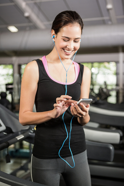 Woman listening to music on treadmill at gym