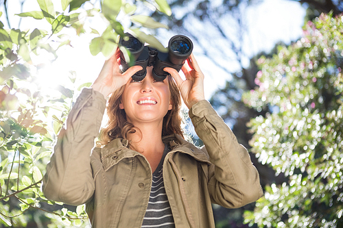 Woman using binoculars in the countryside