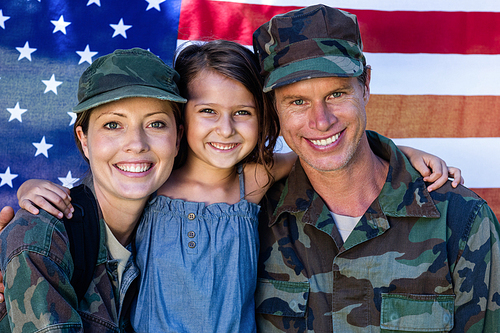 Soldier couple reunited with their daughter in front of american flag