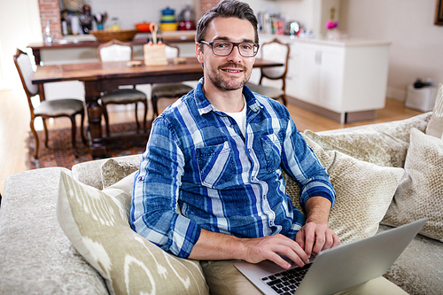 Portrait of man using a laptop at home