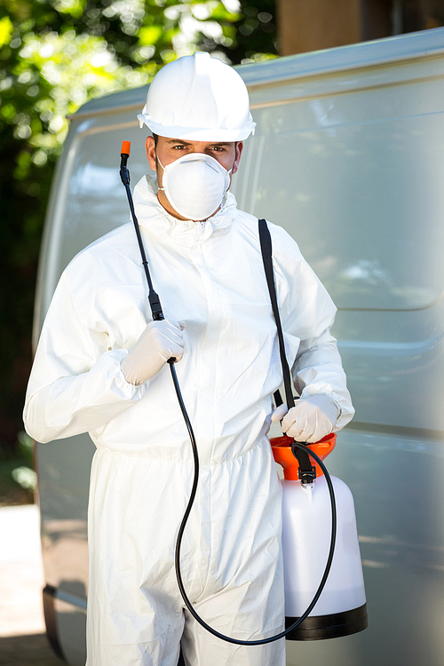 Portrait of pest control man standing next to a van on a street