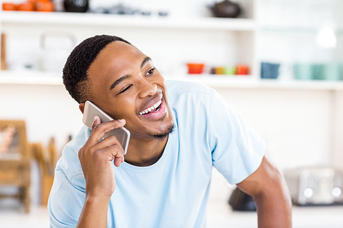 Happy man talking on mobile phone at home