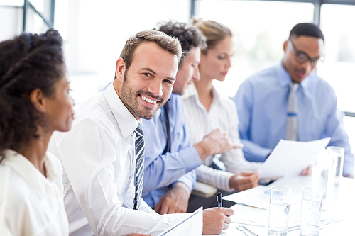 Portrait of businessman writing a report in office