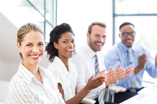 Portrait of businesspeople applauding while in a meeting at office