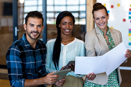 Portrait of young man and women discuss using digital tablet and document in the office