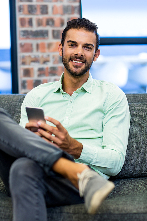 Young man text messaging on mobile phone in the office