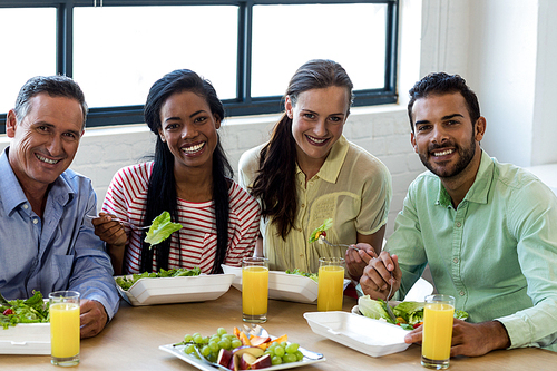 Portrait of colleagues having breakfast together in office