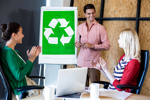 Team applauding a colleague after presentation in the office